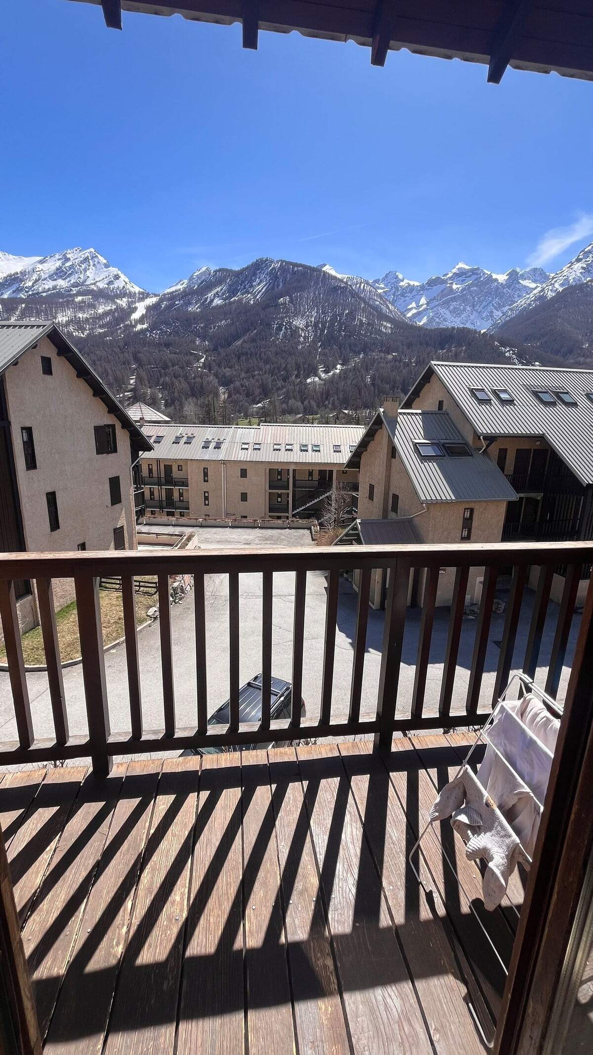 Vue depuis le balcon sur les chalets du village et la barrière de sommets enneigés du Monêtier-les-Bains