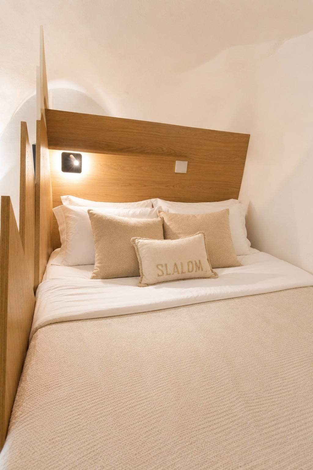 Chambre parentale avec tête de lit en chêne, éclairage de lecture et coussin brodé Slalom
